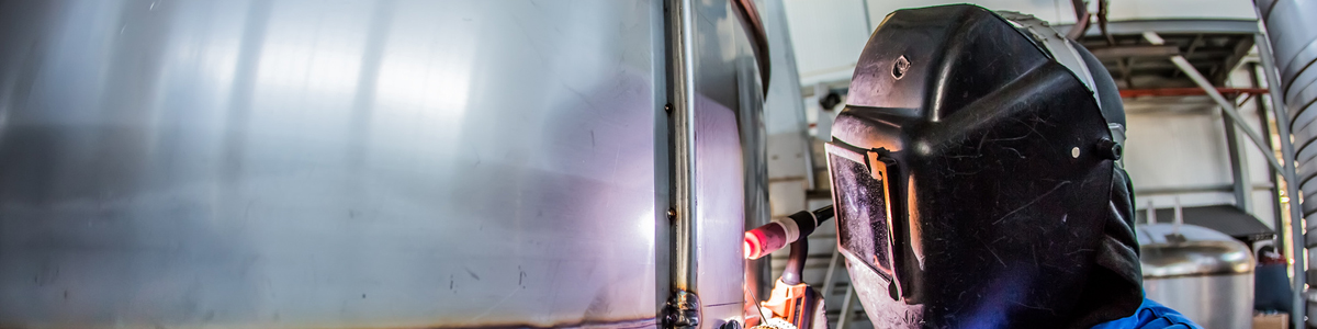 Man welding with reflection of sparks on visor. Hard job.